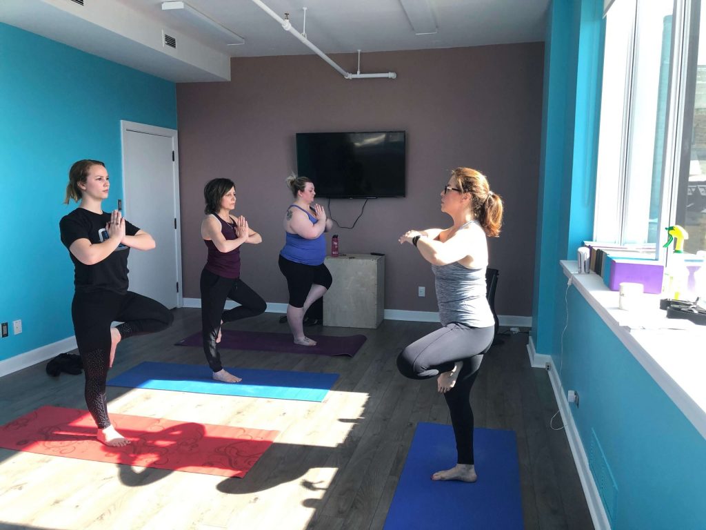 Shelley Butler helping Dovico staff practice Yoga.